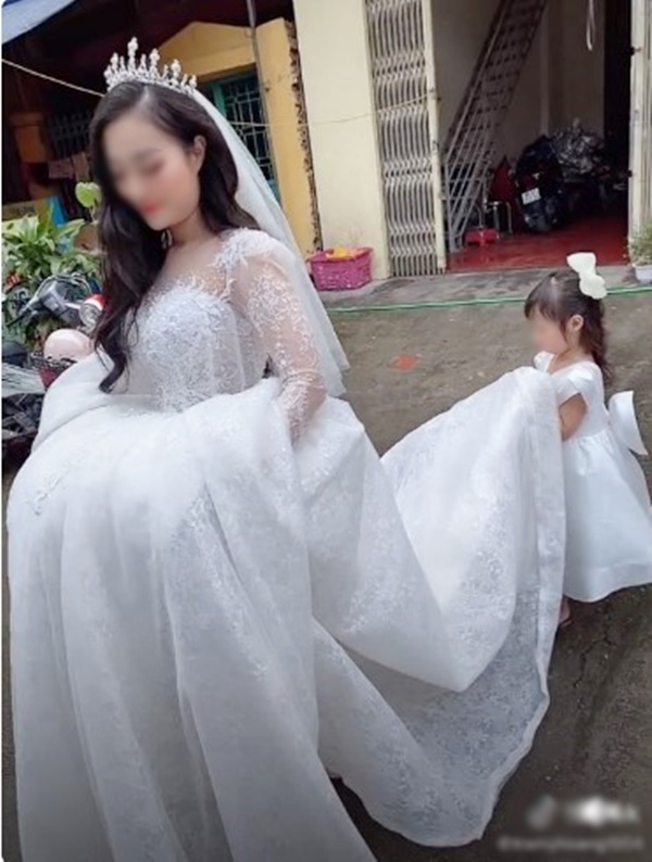 Bé gái mặt buồn thiu nâng váy cưới cho mẹ đi lấy chồng - Ảnh 1
