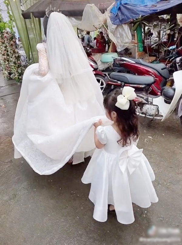 Bé gái mặt buồn thiu nâng váy cưới cho mẹ đi lấy chồng - Ảnh 5