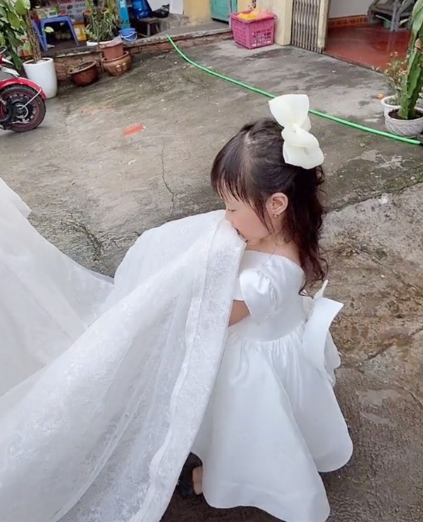 Bé gái mặt buồn thiu nâng váy cưới cho mẹ đi lấy chồng - Ảnh 2